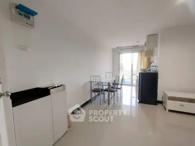 Spacious modern living room with dining area and balcony access in a bright apartment.