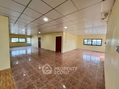 Spacious open-plan interior with tiled flooring and ample natural light.