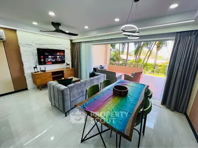 Spacious modern living room with open layout and large balcony, featuring stylish furniture and lush outdoor view.