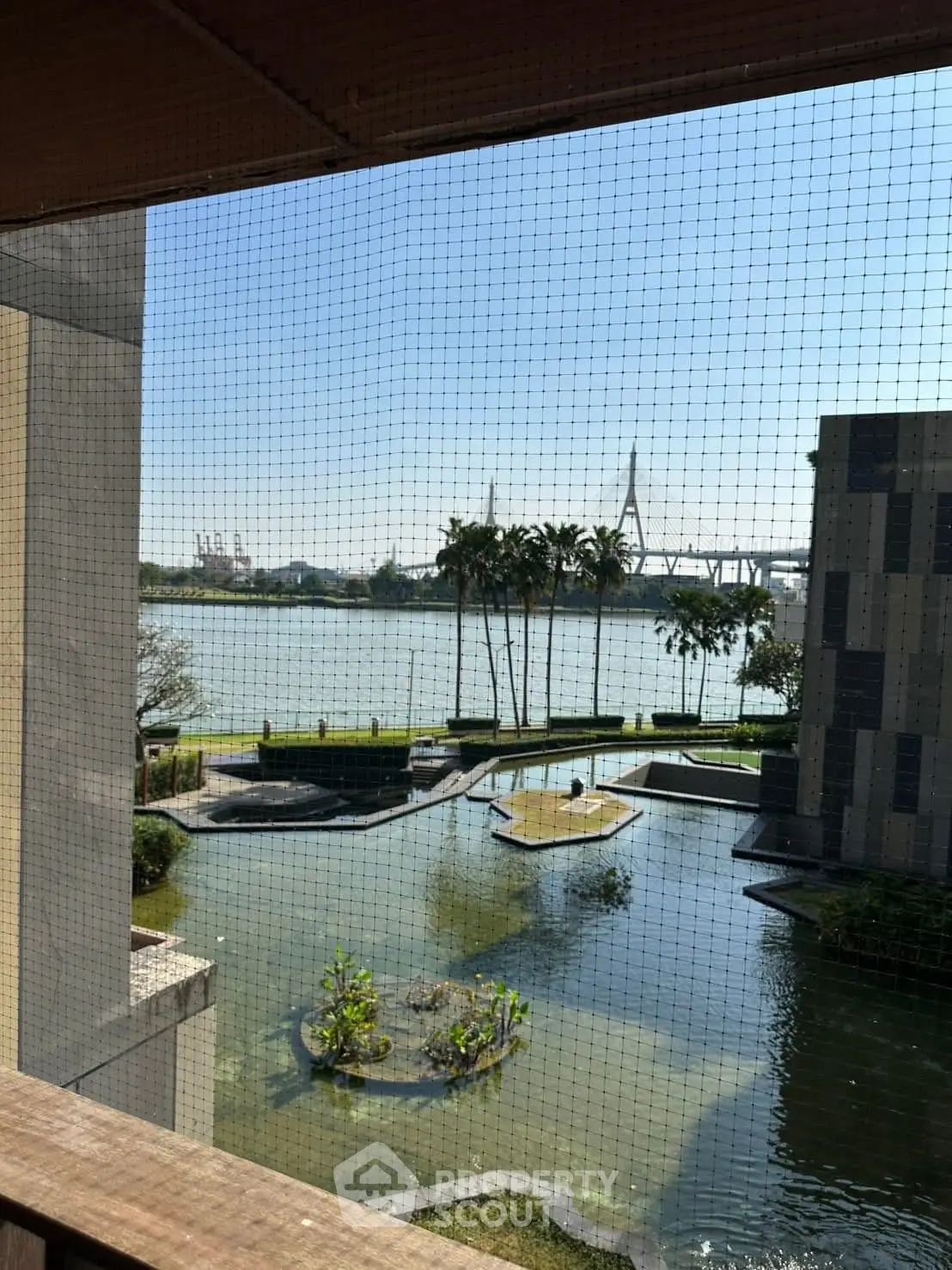 Stunning river view from a balcony overlooking a serene pond and lush greenery.