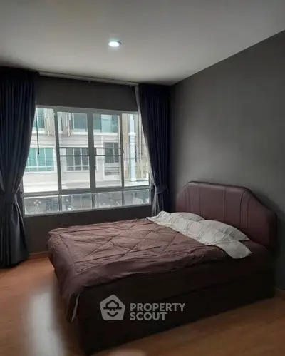 Cozy bedroom with large window and modern decor in urban apartment