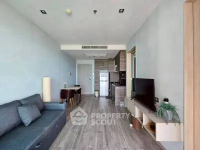 Modern living room with sleek furniture and open kitchen layout in a stylish apartment.