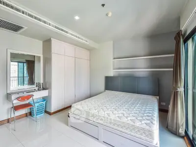 Spacious modern bedroom with large window and built-in wardrobe