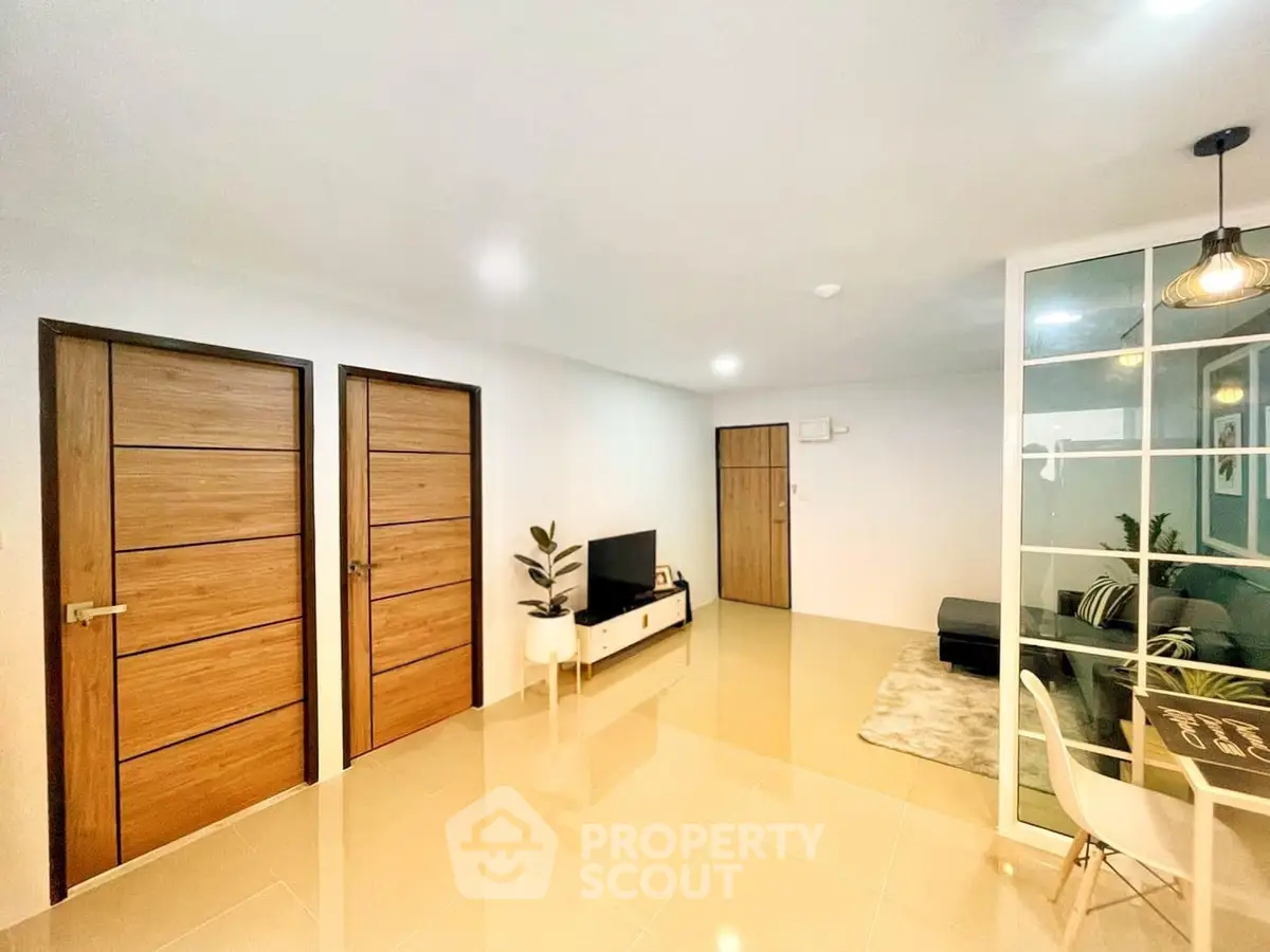 Modern living room with sleek design, glass partition, and stylish decor in a contemporary apartment.