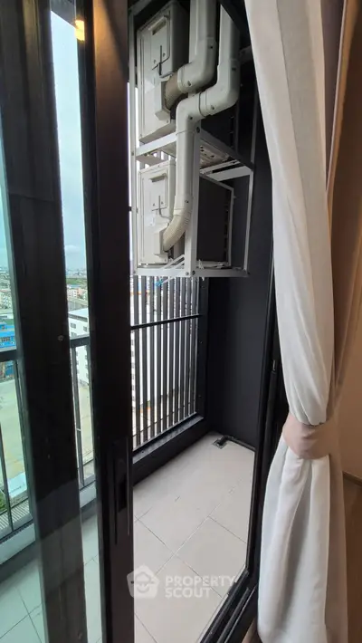 Modern balcony view with cityscape, featuring sleek glass doors and elegant curtains.