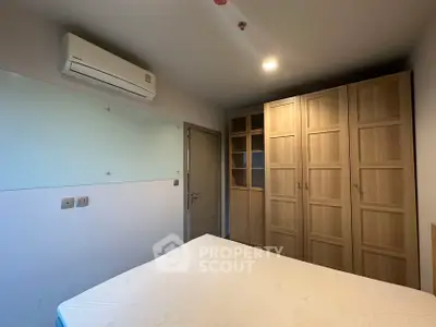 Cozy bedroom with built-in wardrobe and air conditioning unit.