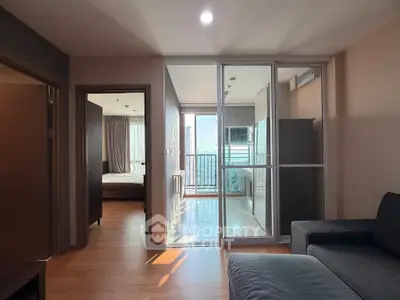 Modern apartment interior with cozy living room and bright balcony view, featuring sleek furniture and natural light.