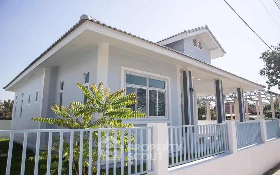 Charming single-story house with modern design and white picket fence, perfect for family living.