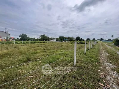 Expansive plot of land with lush greenery and clear skies, ideal for development.