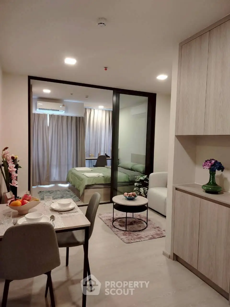 Modern studio apartment with open layout, featuring a cozy living area and stylish dining space.