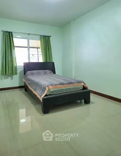 Cozy minimalist bedroom with single bed and green curtains