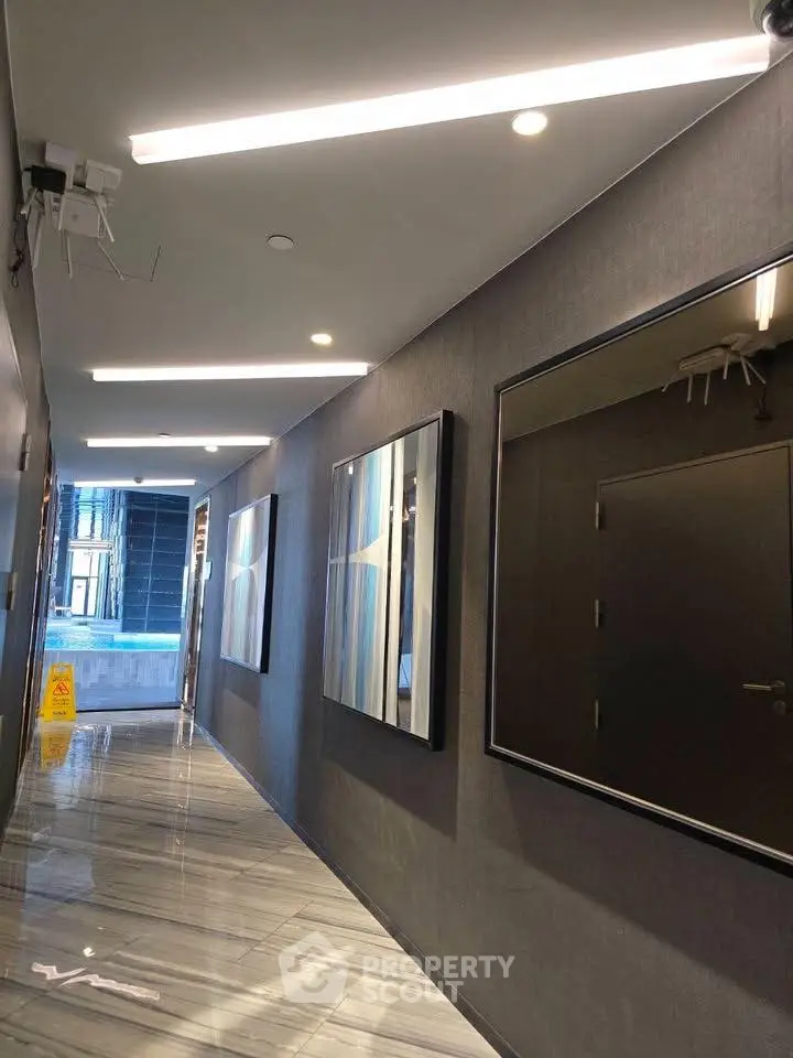 Modern corridor with sleek lighting and polished marble flooring in upscale building.