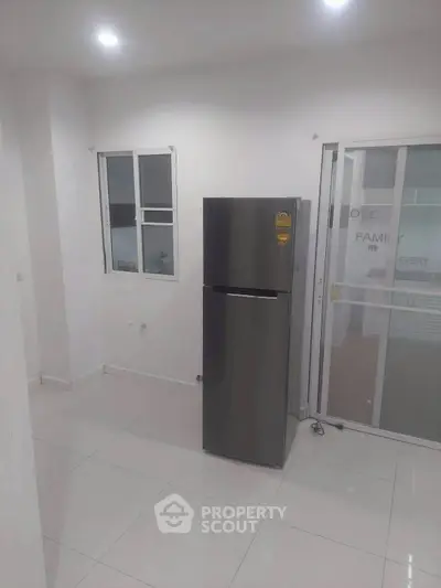 Modern kitchen with sleek refrigerator and sliding glass door