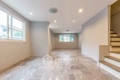 Spacious open-plan living area with natural light and modern flooring