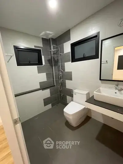 Modern bathroom with sleek design, featuring a spacious shower area and contemporary fixtures.