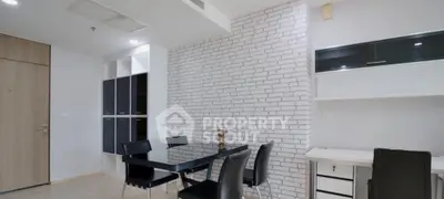 Modern dining area with sleek black furniture and white brick accent wall