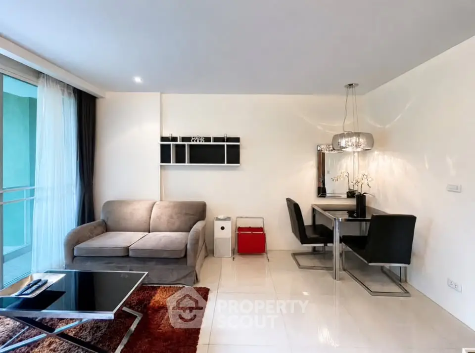 Modern living room with sleek furniture and dining area, featuring a cozy sofa and elegant lighting.
