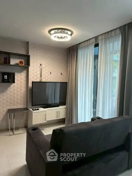 Modern living room with stylish decor and large TV, perfect for relaxation.