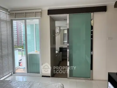Modern bedroom with sliding glass door and balcony view in urban apartment