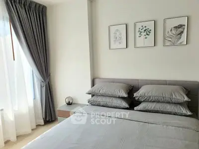Elegant bedroom with modern decor and natural light, featuring stylish artwork and plush bedding.