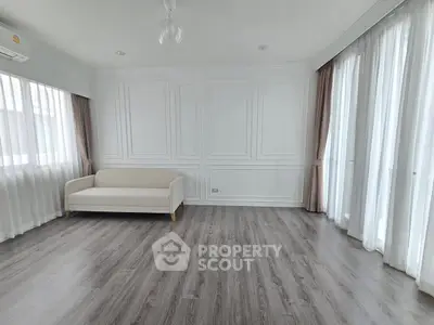 Spacious living room with elegant white walls and large windows.