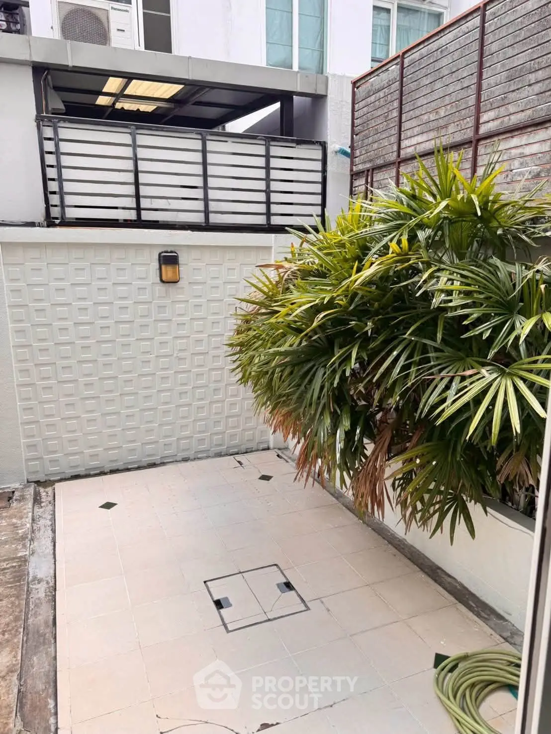 Charming outdoor patio with lush greenery and modern design, perfect for relaxation and entertaining.