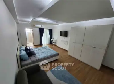 Spacious modern bedroom with stylish decor and ample storage in a contemporary apartment.