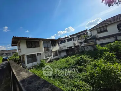 Charming suburban home with lush garden and clear blue sky, perfect for renovation.