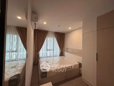 Modern bedroom with large window and stylish curtains in a cozy apartment.