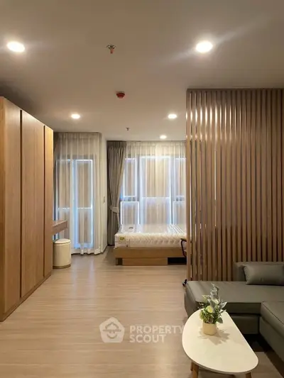Modern studio apartment with stylish wooden accents and cozy furnishings.