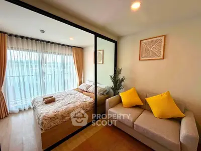 Modern bedroom with cozy sofa and large window, perfect for relaxation and natural light.