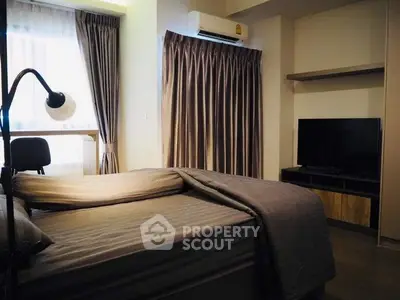Cozy bedroom with modern decor, featuring a comfortable bed, TV, and stylish curtains.