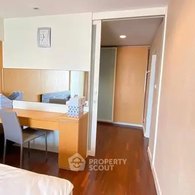 Spacious bedroom with wooden flooring and modern furniture in a stylish apartment.