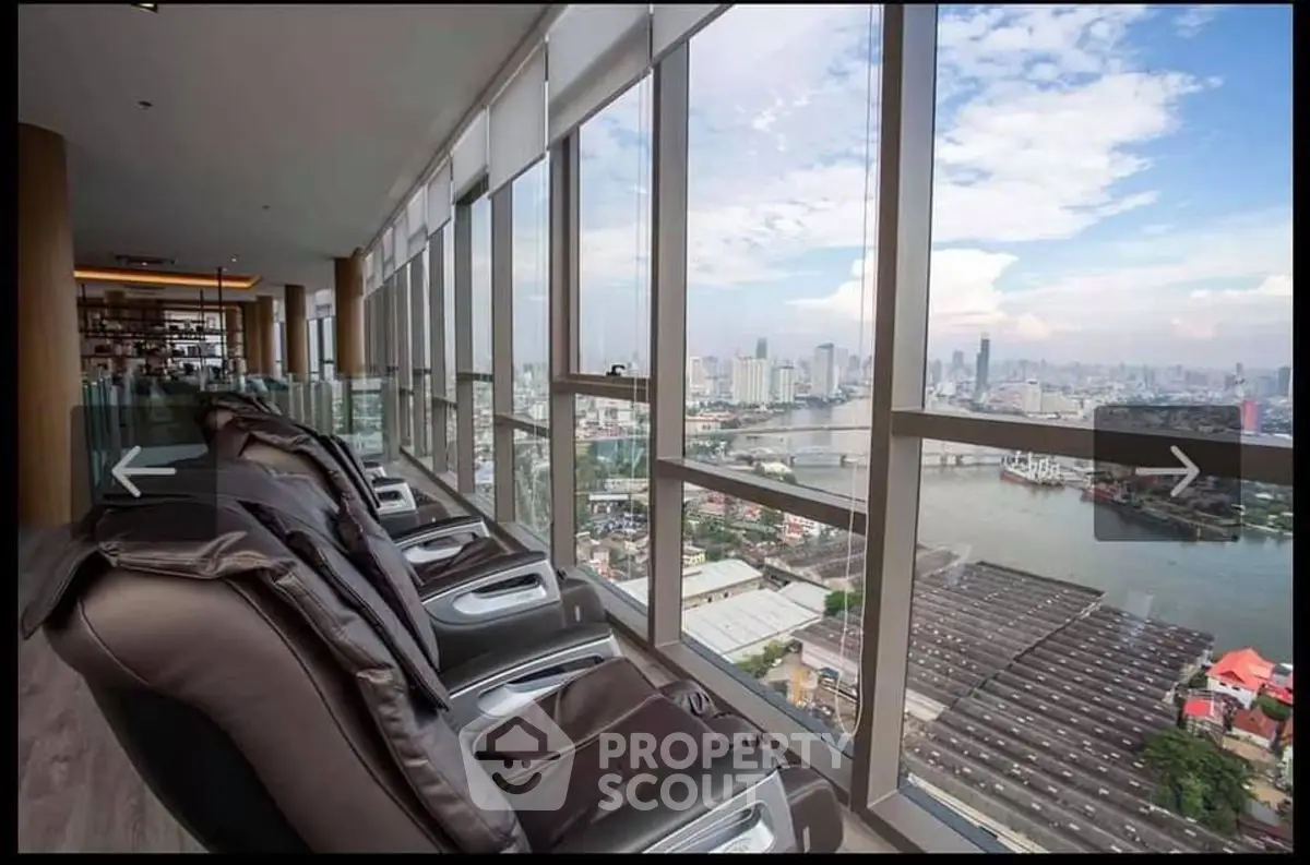 Luxurious high-rise view with massage chairs overlooking city skyline and river
