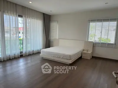 Spacious bedroom with large windows and modern minimalist design.