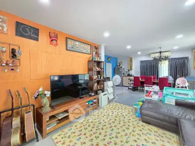 Spacious living room with modern decor and entertainment setup, perfect for family gatherings.