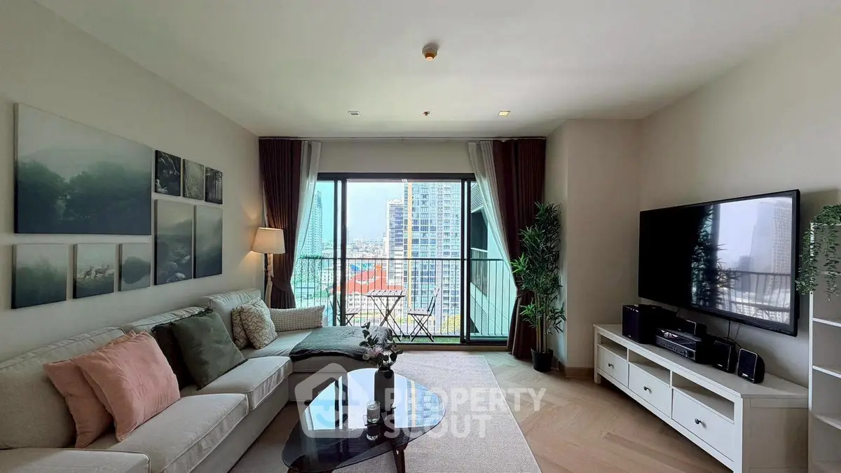 Spacious living room with city view, modern decor, and large TV setup.