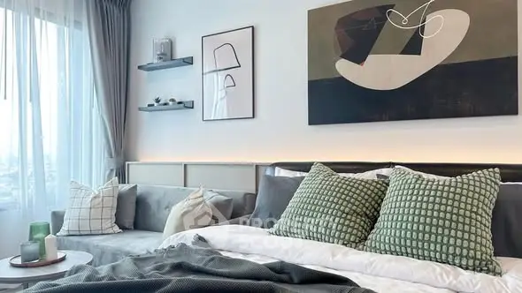 Stylish modern bedroom with cozy seating and abstract art