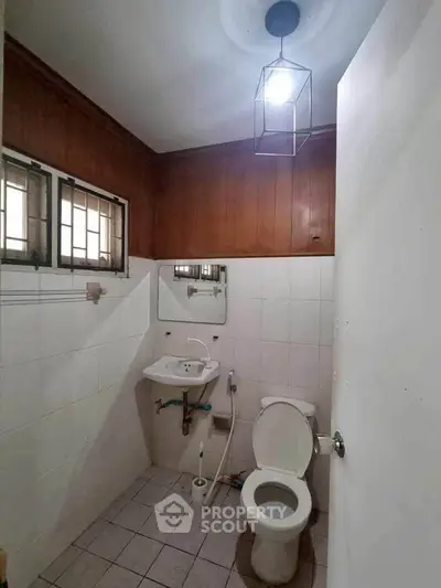 Cozy bathroom with wooden paneling and modern fixtures in a real estate property.