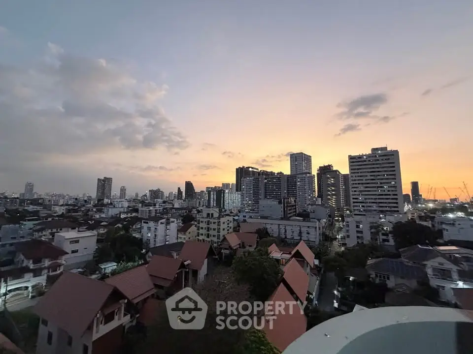Stunning cityscape view at sunset with modern high-rise buildings and charming rooftops.