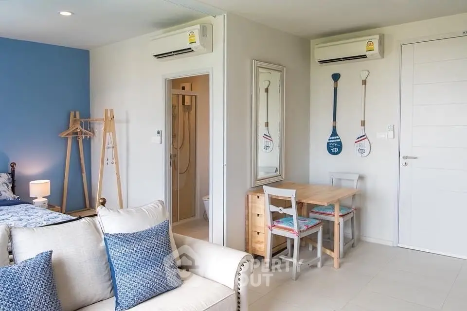 Charming studio apartment with modern decor and cozy living area, featuring air conditioning and stylish furnishings.