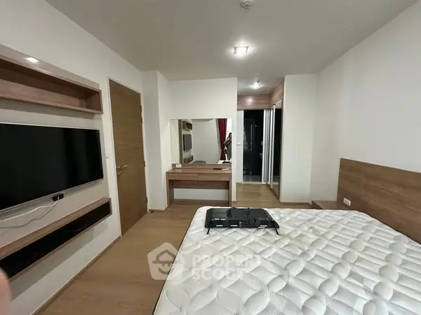 Modern bedroom with wall-mounted TV and wooden accents