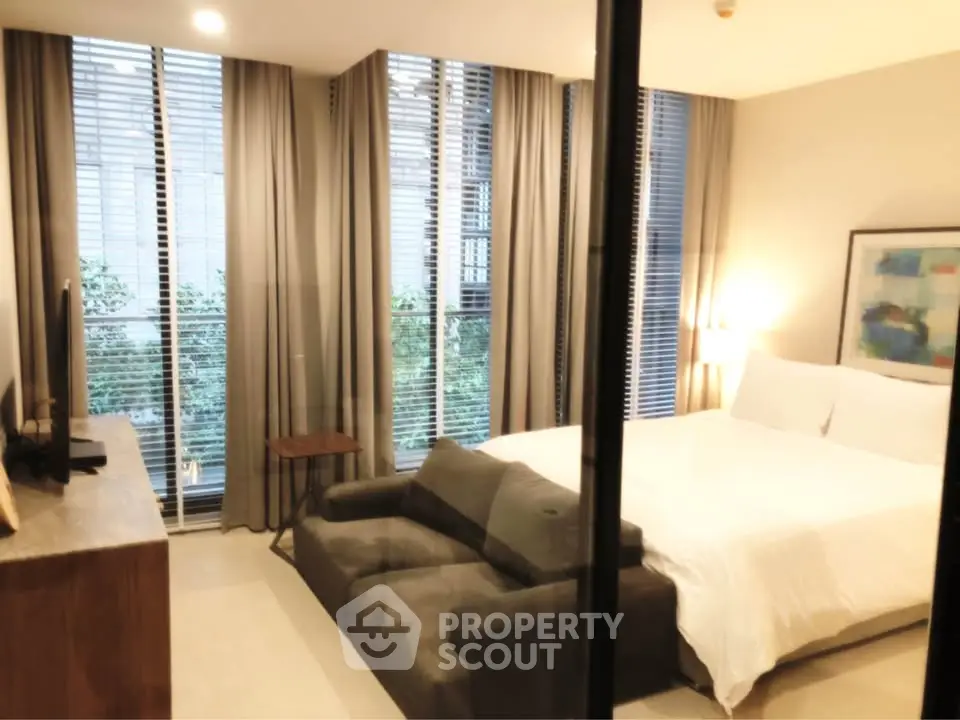 Modern bedroom with large windows and stylish decor in a luxury apartment.