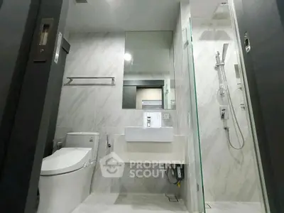 Modern bathroom with sleek design, featuring a glass shower and elegant fixtures.