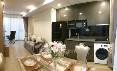 Modern open-plan living room and kitchen with elegant dining setup and striped sofa.