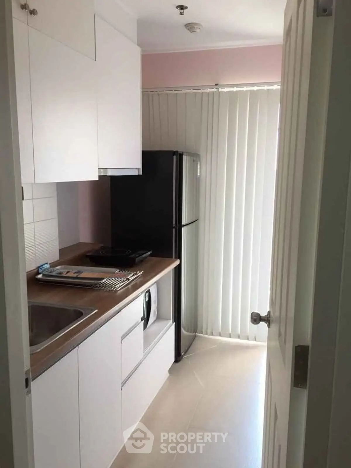 Compact kitchen with modern appliances and natural light