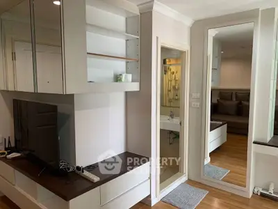 Modern apartment interior with sleek living room and bathroom, featuring wooden flooring and built-in storage.