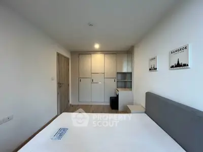 Modern bedroom with built-in wardrobe and minimalist decor in Bangkok apartment.