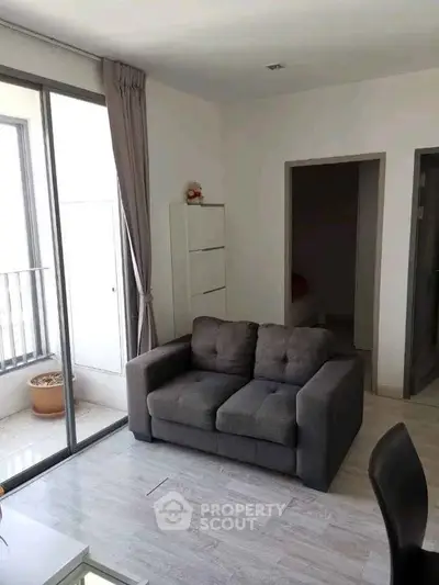 Modern living room with cozy sofa and balcony access in bright apartment