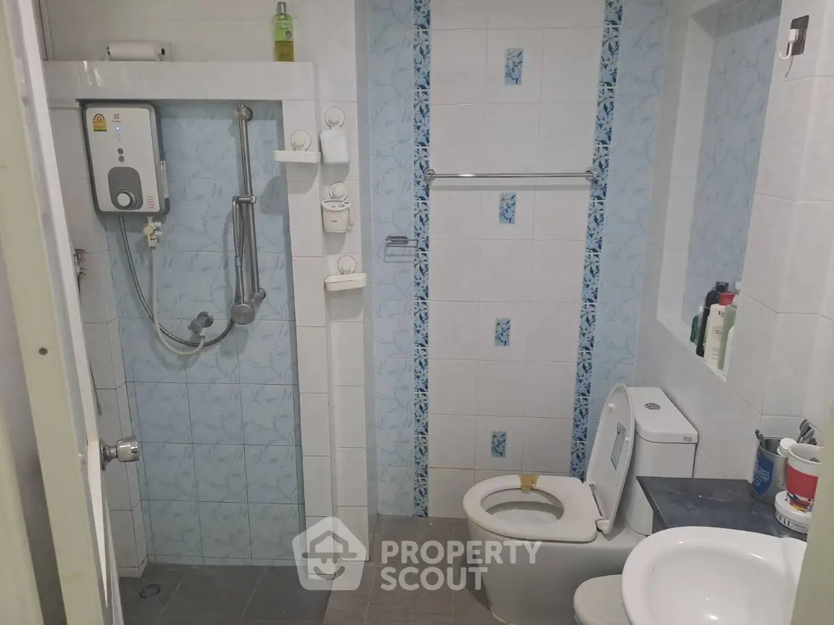 Modern bathroom with shower, toilet, and sink in a compact layout.